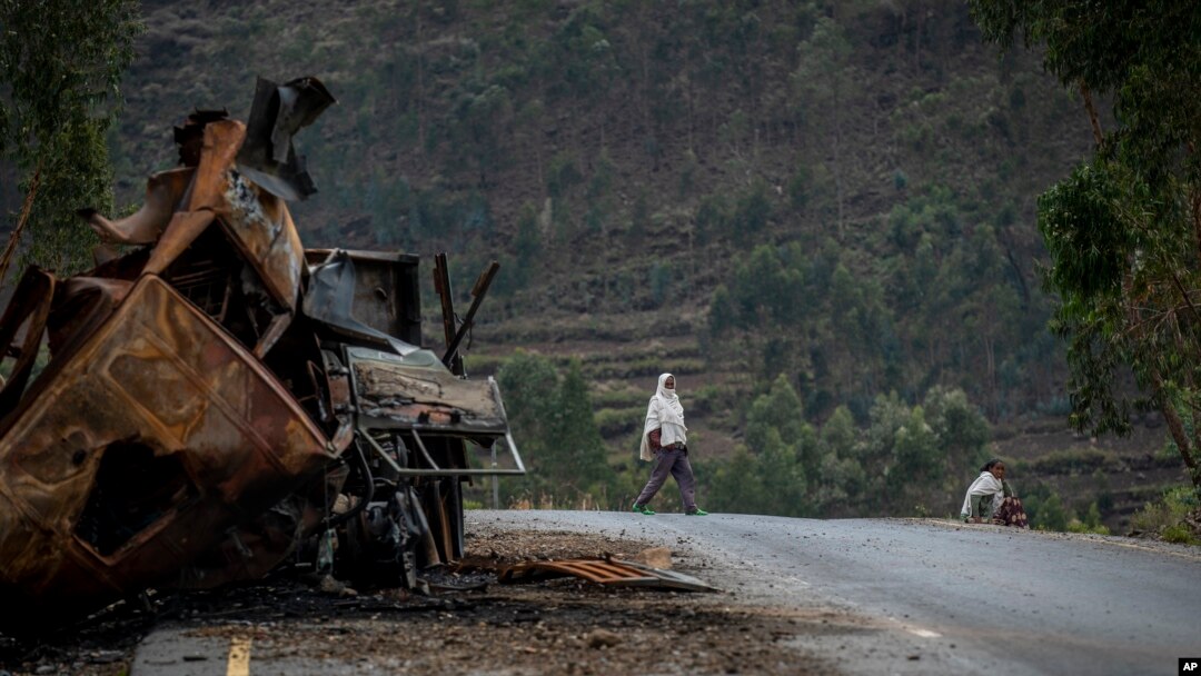 Mtu mmoja akivuka karibu na lori lililoharibiwa kwenye barabara inayoelekea mji wa Abi Adi, katika eneo la Tigray kaskazini mwa Ethiopia wakati wa mapigano Mei 11, 2021.