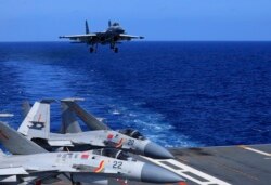 A J-15 fighter jet preparing to land on the Chinese navy's Liaoning aircraft-carrier during combat training in the South China Sea. Photo released December 31, 2021. (Hu Shanmin/Xinhua via AP)