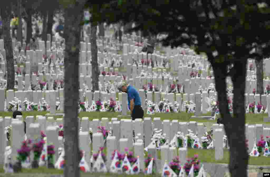A South Korean man visits the grave of his relative killed in the 1950-53 Korean War, at the National Cemetery in Seoul, on the Korean Memorial Day.