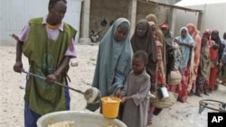Somalis recebem alimentos num campo em Mogadíscio. Milhares de pessoas chegaram a Mogadíscio nas últimas semanas procurando assistência