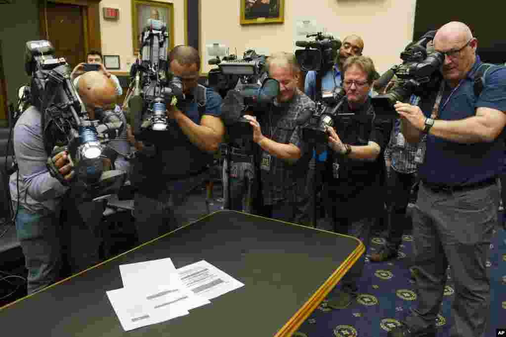 Photojournalists photograph four pages of the Mueller Report laid on the witness table in the House Intelligence Committee hearing room on Capitol Hill. The redacted version of Special counsel Robert Mueller's 400-page report on his investigation into Russian meddling in the 2016 U.S. election is released by Attorney General William Barr.