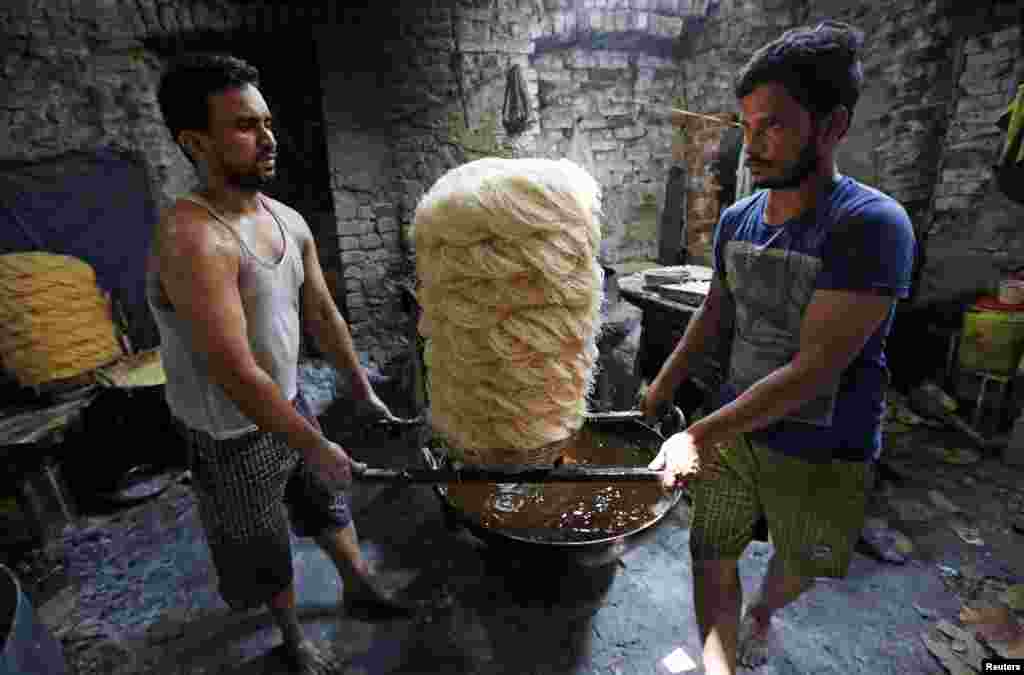 Men carry vermicelli, a specialty eaten during the Muslim fasting month of Ramadan, at a factory in Kolkata, India, May 27, 2019.