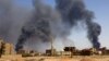 FILE - A man walks while smoke rises above buildings after aerial bombardment, during clashes between the paramilitary Rapid Support Forces and the army in Khartoum North, Sudan, May 1, 2023. 