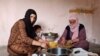 Ismahan, left, and her mother make traditional food using leaves plucked from trees, because they can not afford to buy them on May 20, 2020 in Istanbul. (Heather Murdock/VOA)