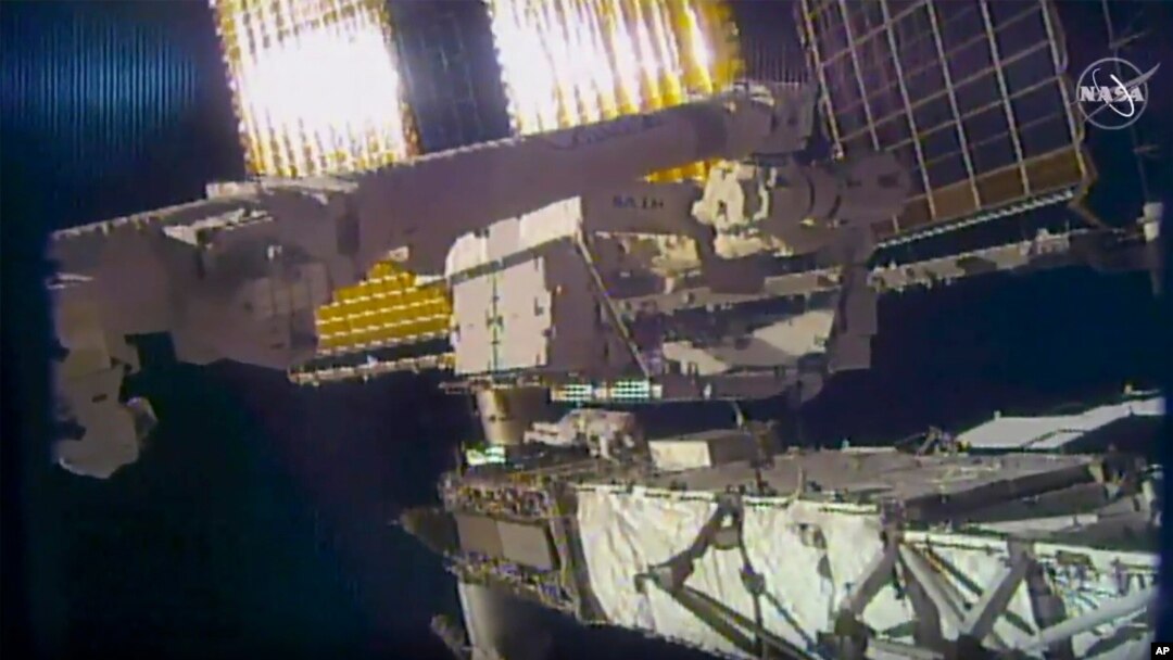 This photo provided by NASA shows NASA astronaut Chris Cassidy and NASA Flight Engineer Bob Behnken during a spacewalk outside the International Space Station, June 26, 2020. 