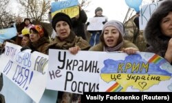 UKRAINE – Participants hold placards and shout slogans during an anti-war rally in the Crimean village of Eskisaray, outside Simferopol, March 10, 2014
