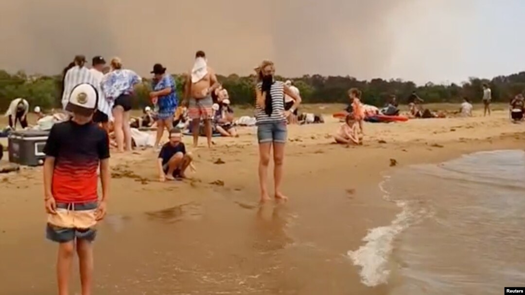 Personas atrapadas junto al mar tras huir de los incendios forestales en Batemans Bay, Australia el 31 de diciembre de 2019.
