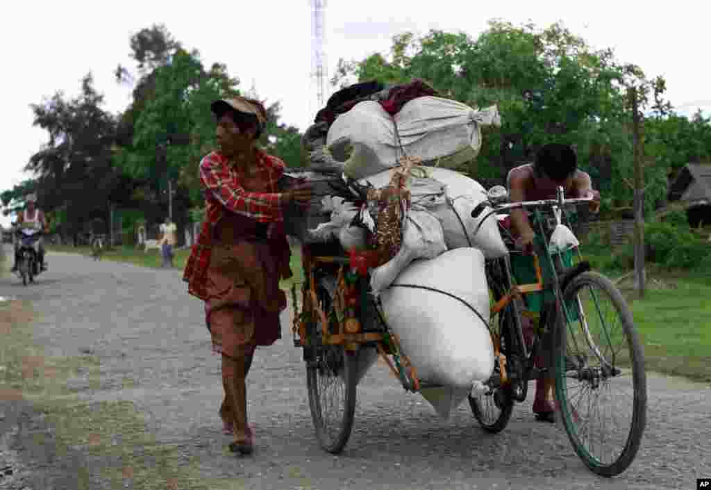 Cư dân địa phương đẩy một xe ba bánh chất đầy vật dụng tại Sittwe, nơi bạo động giáo phái ảnh hưởng đến dân chúng địa phương, 11/6/2012.