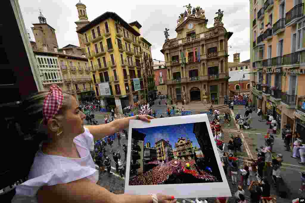 Cristina Esparza holds a San Fermin July 2019 photograph, in Pamplona, northern Spain, on the day the ''txupinazo'' would usually take place to start the famous San Fermin festival, which was canceled again this year due to the COVID-19 pandemic.