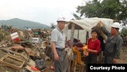 북한 적십자 소속 재난대응요원들이 지난 8월 말 함경북도 회령시 주변 홍수 피해 지역에서 피해 규모를 파악하고 있다. 국제적십자가 지난달 20일 공개한 북한 수해 보고서에 들어있는 사진.