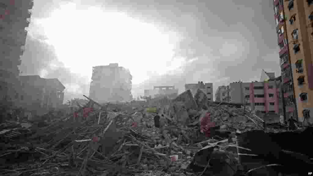 Palestinians inspect the rubble of the Al-Zafer apartment tower following Israeli airstrikes Saturday that collapsed the 13-story building, in Gaza City, Aug. 24, 2014.