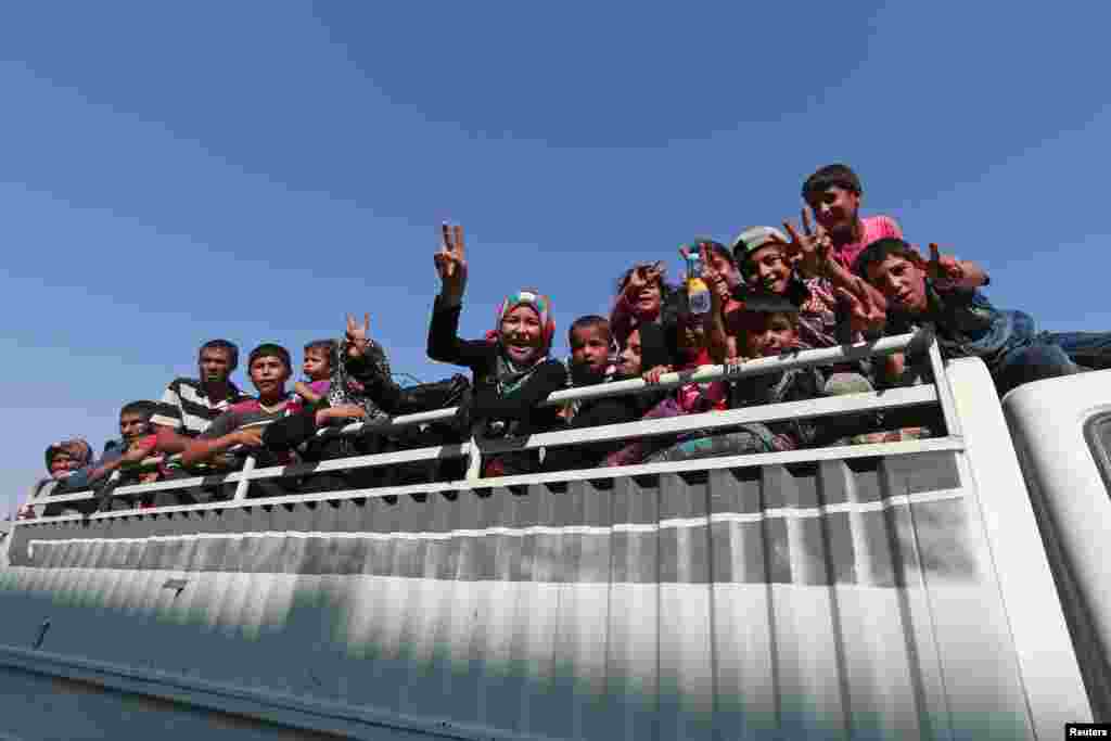 Civilians react atop of a pickup truck after they were evacuated by the Syria Democratic Forces (SDF) fighters from an Islamic State-controlled neighborhood of Manbij, in Aleppo Governorate, Syria, Aug. 12, 2016.