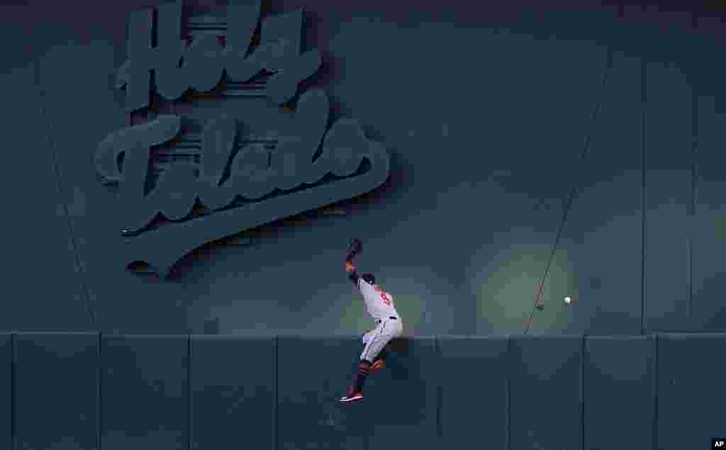 Baltimore Orioles center fielder Keon Broxton tries to catch a solo home run hit by Oakland Athletics' Beau Taylor during the third inning of a baseball game in Oakland, California, June 18, 2019.