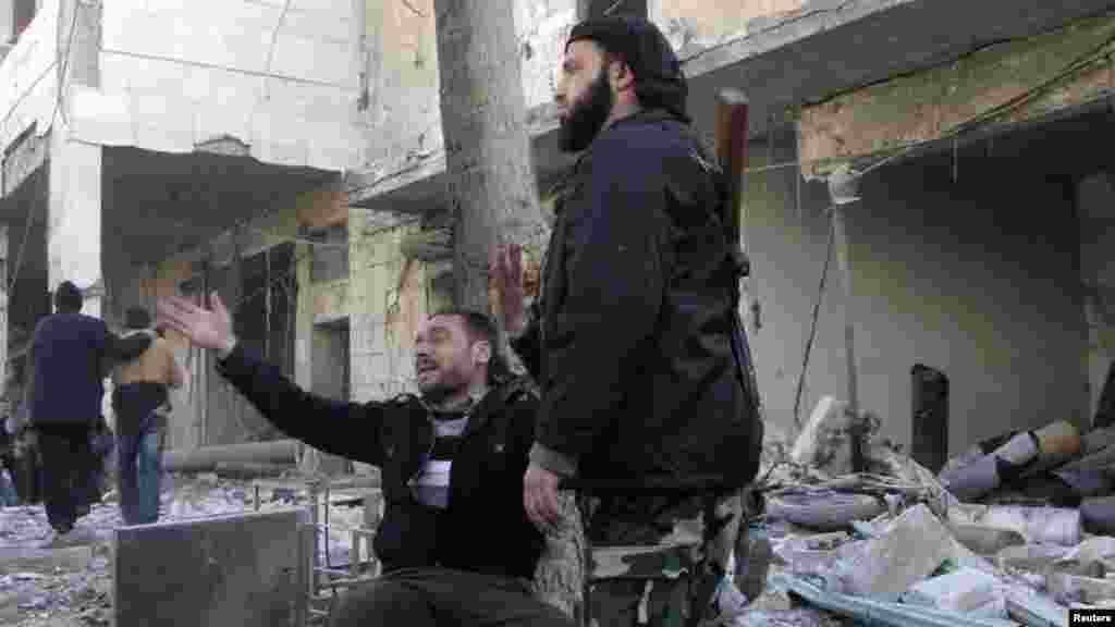 A man reacts at the site of what activists said was an air raid by forces loyal to Syrian President Bashar Al-Assad in the al-Marja district of Aleppo, Dec. 23, 2013. 