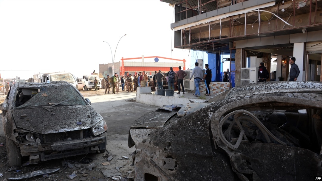 Iraqis gather at the site of a car bomb in Mosul, Iraq, Nov. 9, 2018. The previous night's explosion killed three people, the first such attack since jihadists were ousted from the city last year.