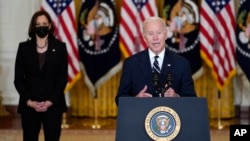 Vice-presidente Kamala Harris (esq) e Presidente Joe Biden (dir) falam na Casa Branca, 28 Outubro 2021