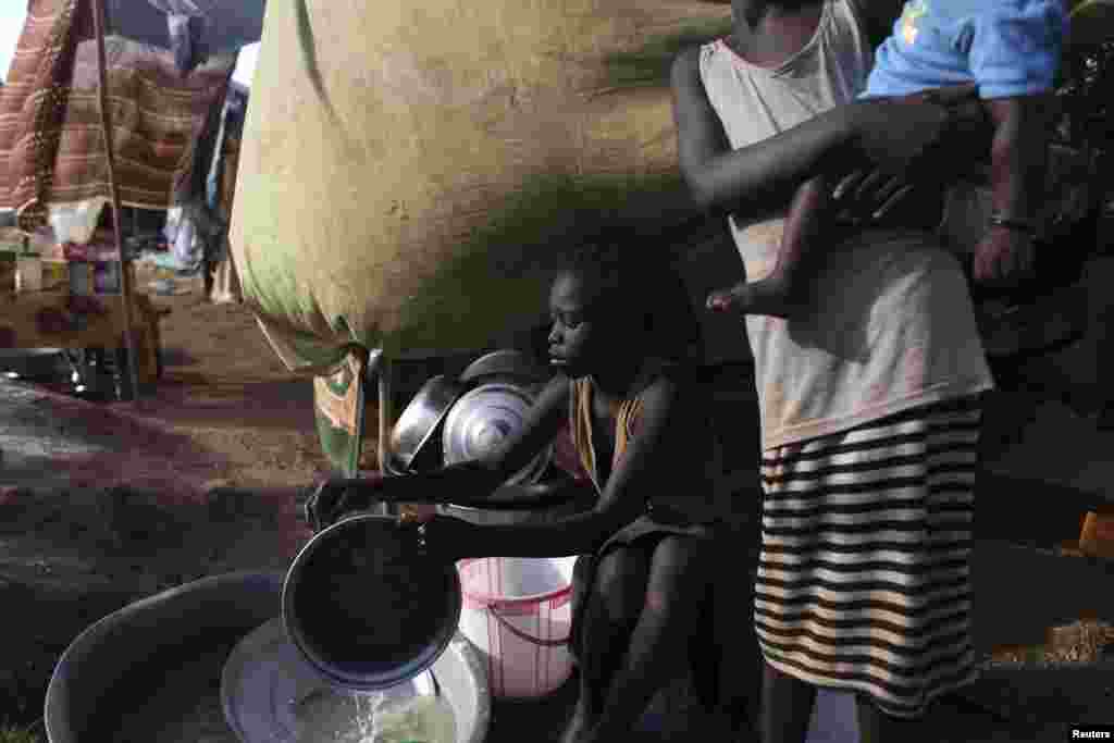 A South Sudanese girl washes dishes in a camp for displaced persons in the UNMISS compound in Tongping, Juba, South Sudan, Feb. 19, 2014. 