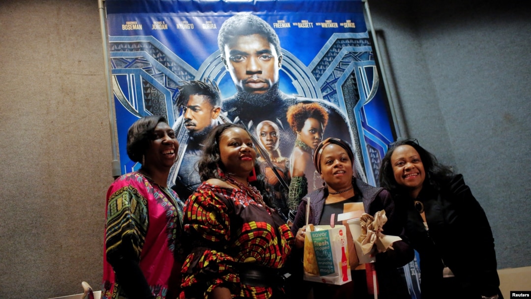 A group of women pose for a photo in front of a poster advertising the film "Black Panther" on its opening night of screenings at the AMC Magic Johnson Harlem 9 cinemas in Manhattan, New York, U.S., February 15, 2018. (REUTERS/Andrew Kelly)