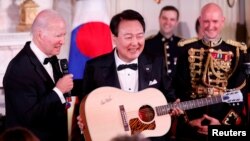美國總統拜登在白宮贈送韓國總統尹錫悅一把吉他。（2023年4月26日）