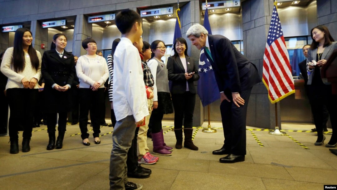 U.S. Secretary of State John Kerry (3rd R) chats with one of Chinese teacher Peng Ye (4th R)'s four students during an issuance ceremony to be the first Chinese citizens to receive ten-year U.S. visas from Kerry at the U.S. embassy, in Beijing, November 1