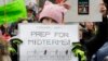 FILE - A woman holds a sign promoting voting in the upcoming midterm elections during a Women's March in Seattle, Jan. 20, 2018.