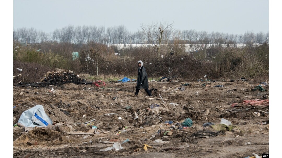 FILE - A man walks among remains of taken down shelters during the dismantling of the southern part of the so-called "Jungle" migrant camp in Calais, northern France, March 10, 2016.