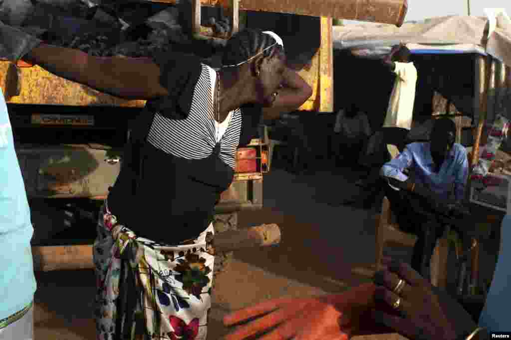 South Sudanese women collect garbage in a camp for displaced persons in the United Nations Mission in South Sudan (UNMISS) compound in Tongping in Juba, South Sudan, Feb. 19, 2014. 