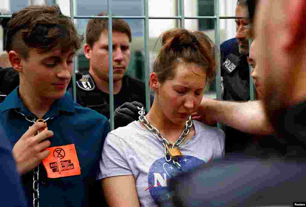 Police officers remove the chains of climate activists demonstrating outside the Chancellory in Berlin, Germany.
