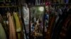 A mirror reflects women as they browse fashion accessories at a New Year bazaar in Beijing on Jan. 1, 2024. U.N. economists reported Thursday that they expect slow global growth this year but said they were optimistic about China's outlook.