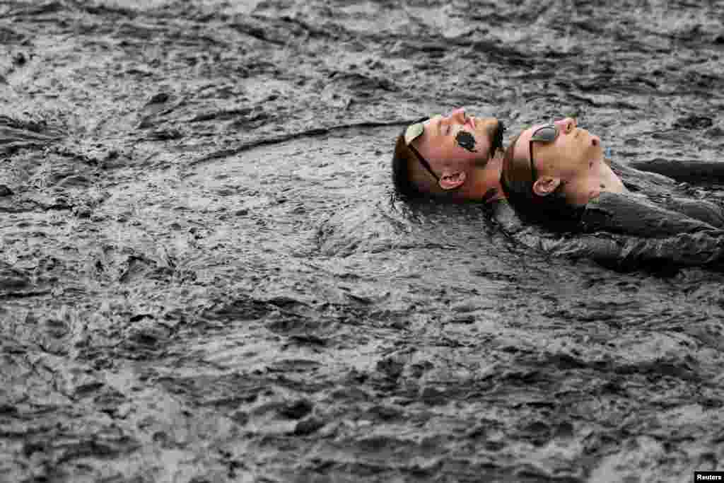 People take a mud bath during the "Iron Mud" festival in the town of Zheleznovodsk, in Stavropol region, Russia, Aug. 24, 2019.