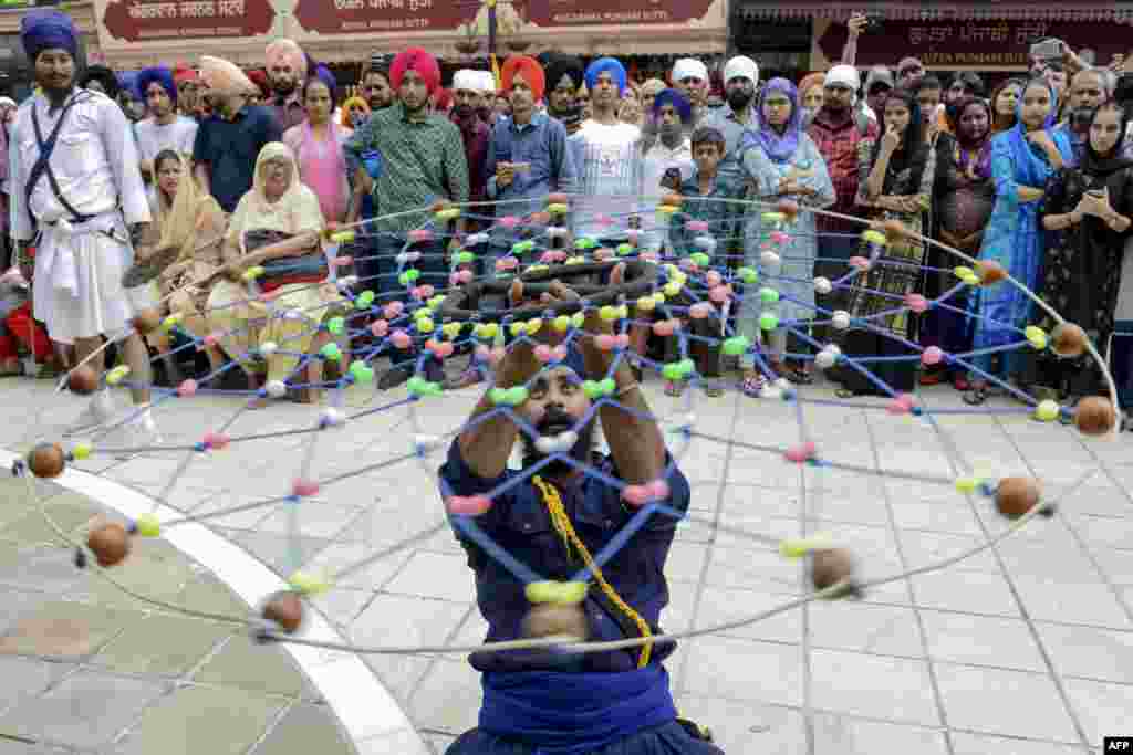 A Sikh devotee demonstrates his 'Gatka' traditional martial art skills during the 'Nagar Kirtan' procession marking the 550th birth anniversary of Guru Nanak Dev, the founder of Sikhism, at the Golden Temple in Amritsar, India.
