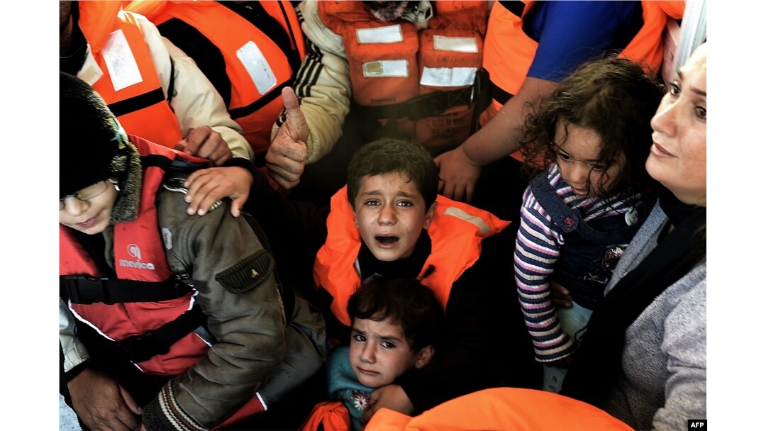 FILE - Syrian Kurdish refugees are rescued by Greek fishermen as the boat they were on sinks off the Greek island of Lesbos after crossing the Aegean Sea from Turkey, Oct. 30, 2015.