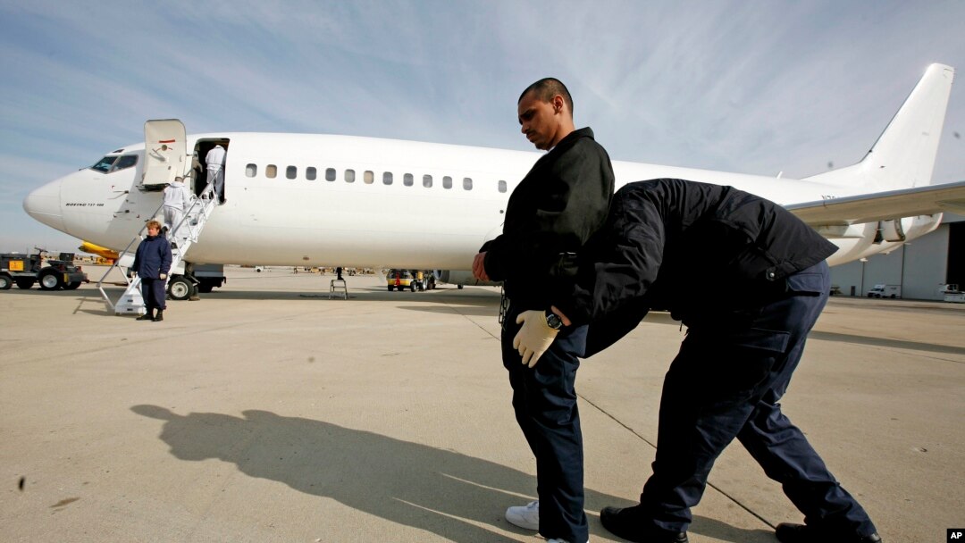 ARCHIVO - En esta foto de archivo del 14 de marzo de 2008, un agente de EE. UU. registra a Gerardo López Arellano, de 24 años, en el Aeropuerto Internacional O'Hare de Chicago antes de escoltarlo a un avión para su deportación a México . (AP Photo / Brian Kersey, Archivo). Un juez hizo regresar un vuelo con inmigrantes deportadas el jueves 9 de agosto de 2018, al enterarse de la deportación durante una audiencia. Las mujeres son demandantes en juicio contra el gobierno de EE.UU.