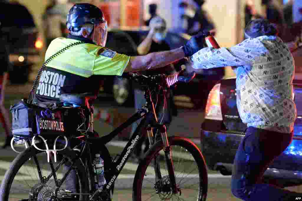 A police officer sprays a protester with pepper spray during a demonstration over the death of George Floyd, an unarmed black man who died in Minneapolis Police custody, in Boston, Massachusetts on May 31, 2020.