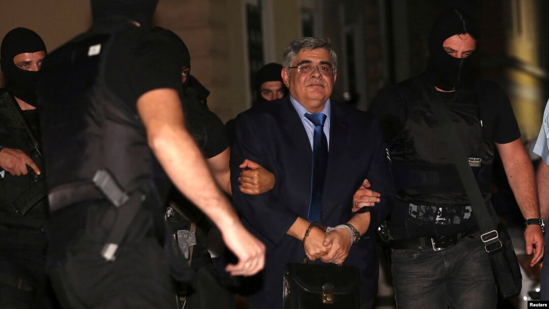 Extreme-right Golden Dawn party leader Nikolaos Michaloliakos is escorted by anti-terrorism police officers into a court house in Athens, Oct. 2, 2013.