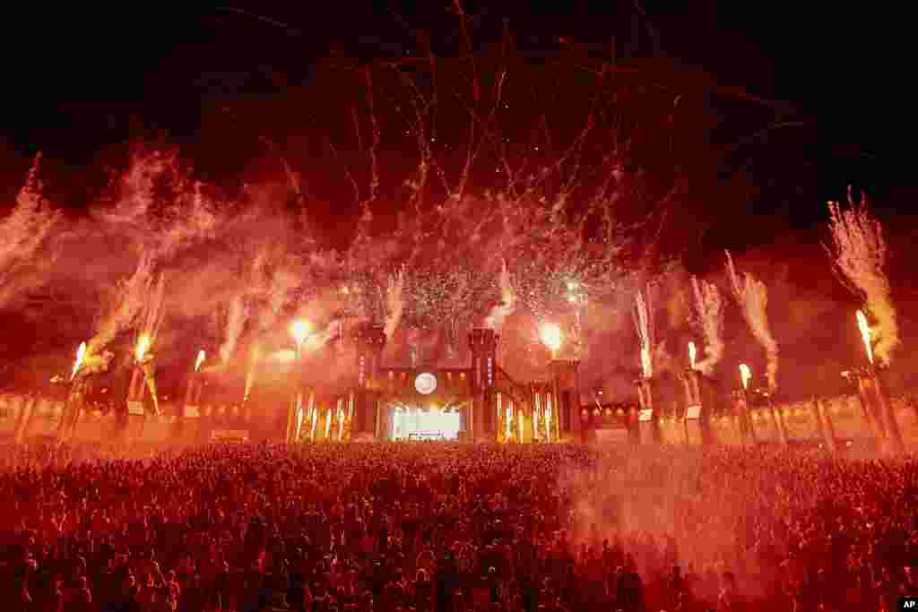 Techno fans dance at the New Horizons festival at the N'rburgring on the Mainfloor during a fireworks display, Aug. 24, 2019, in Nurburg, Germany.
