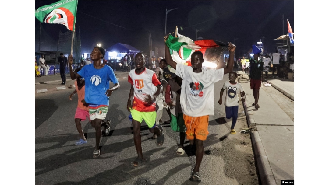 Supporters of Ghana's main opposition National Democratic Congress party candidate and former Ghanian President John Dramani Mahama celebrate after he won in polling stations in the Jamestown neighborhood of Accra, Ghana, Dec. 7, 2024.