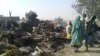 People return to the site after a bombing attack by a Nigerian military jet of an internally displaced persons camp in Rann, Nigeria Jan. 17, 2017. Officials say the bombing was an accident and is under investigation.