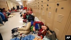Emily Hindle lies on the floor at an evacuation shelter set up at Rutherford High School, in advance of Hurricane Michael, which is expected to make landfall today, in Panama City Beach, Fla., Oct. 10, 2018.