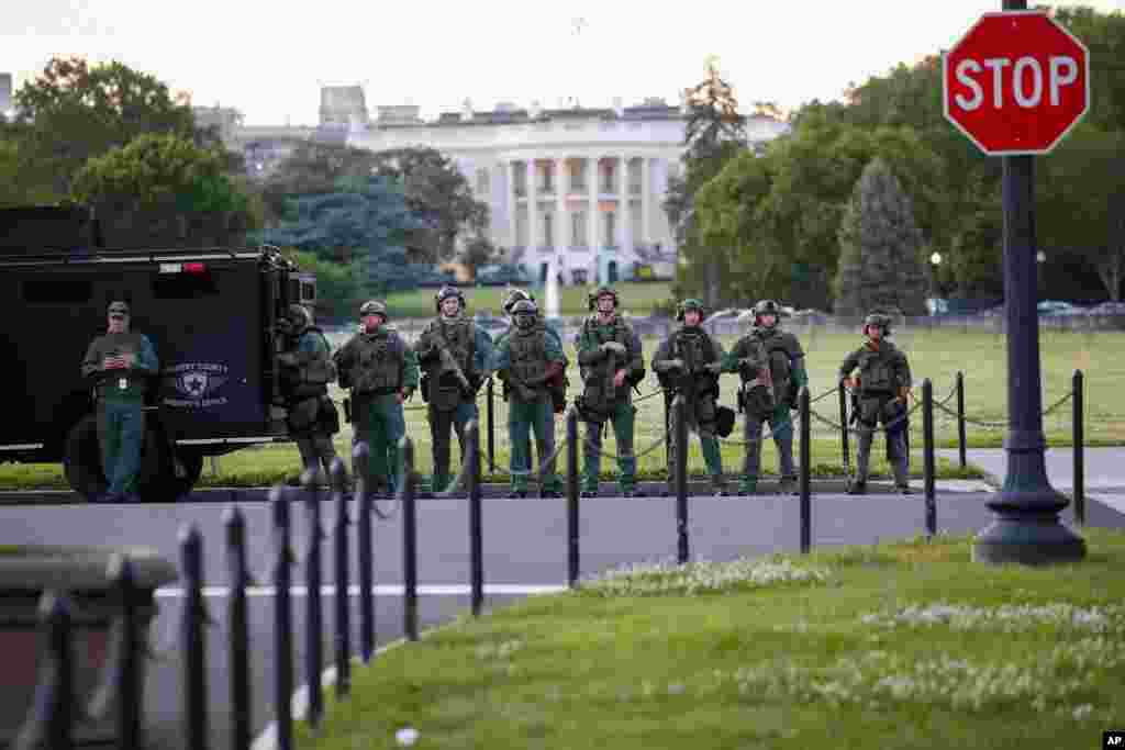 Law enforcement officers from Calvert County Maryland Sheriff's Office standing on the Ellipse, area just south of the White House in Washington, as they watch demonstrators protest the death of George Floyd, May 31, 2020.