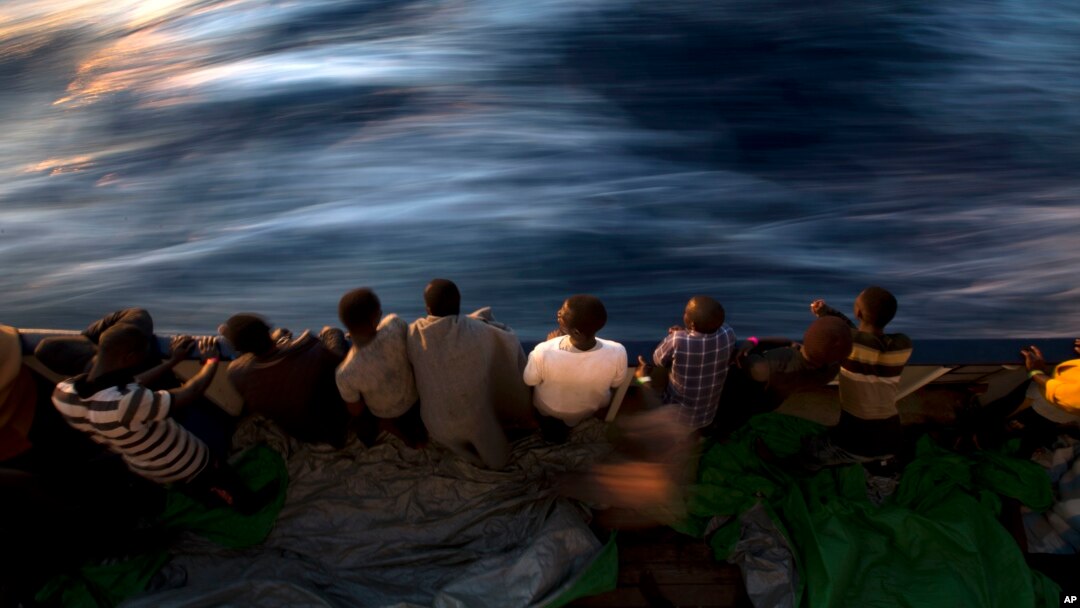 FILE - Migrants and refugees stand on the deck of the rescue vessel Golfo Azzurro after being rescued by Spanish NGO Proactiva Open Arms workers on the Mediterranean Sea, June 16, 2017. 