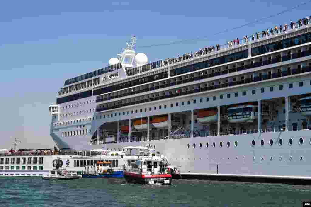 Rescuing boats of the Carabinieri Police (Front) and the port's fire rescue service (2ndL) assist the damaged River Countess tourist boat (Rear L) after it was hit by the MSC Opera cruise ship (R) that lost control as it was coming in to dock in Venice, Italy. Tourists on land could be seen running away as the MSC Opera scraped along the dockside, its engine blaring, before knocking into the River Countess tourist boat.