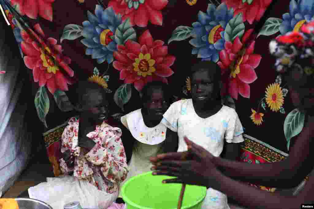 South Sudanese girls sit by a tent in a camp for displaced persons in the United Nations Mission in South Sudan (UNMISS) compound in Tongping, Juba, South Sudan, Feb. 19, 2014. 