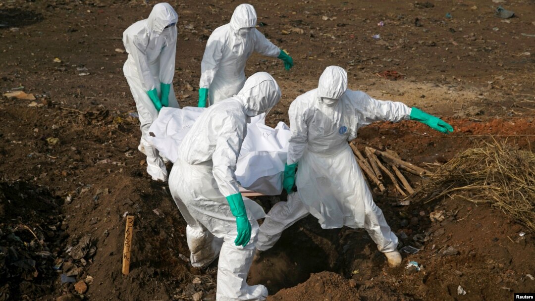 FILE - Health workers carry the body of a suspected Ebola victim for burial at a cemetery in Freetown, Sierra Leone, Dec. 21, 2014. 