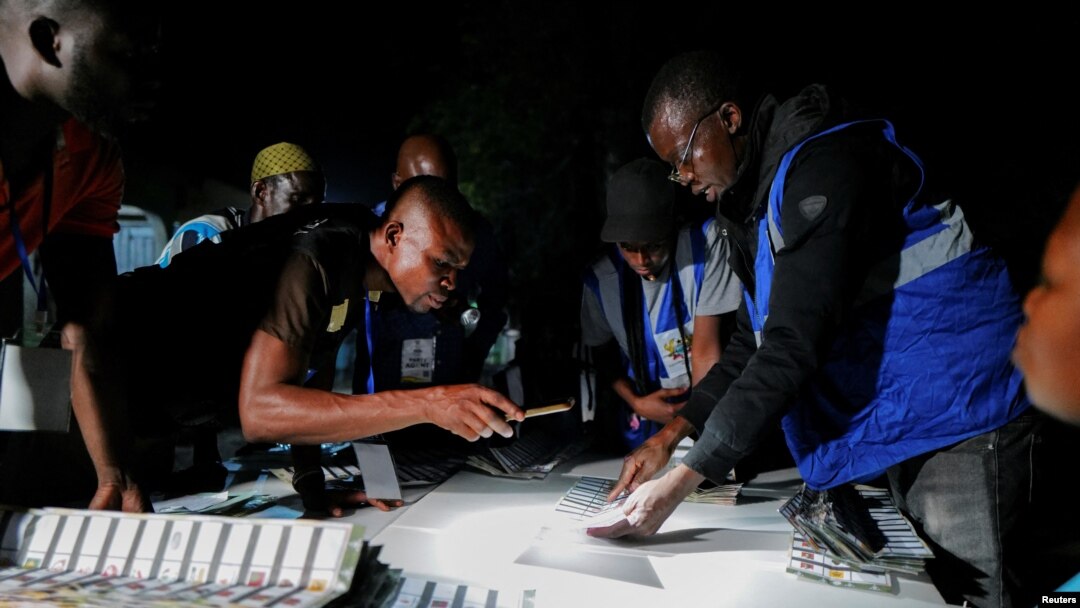 Electoral officials count votes during the presidential and parliamentary election at a polling station in Bole, Ghana, Dec. 7, 2024.