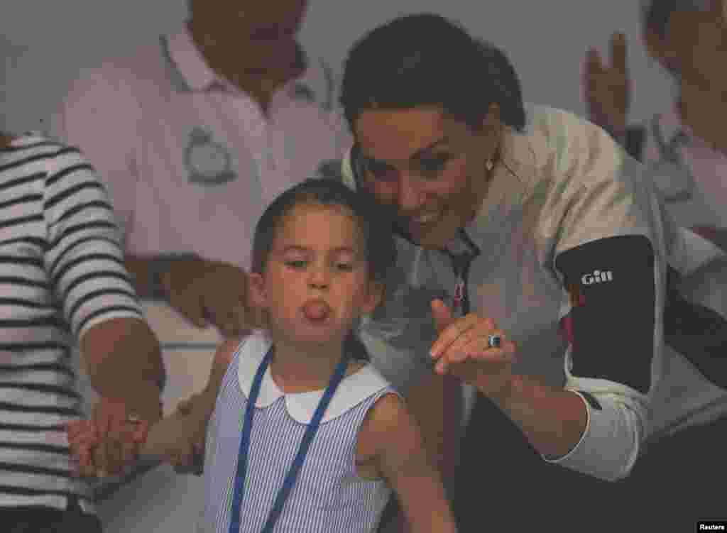 Britain's Princess Charlotte sticks her tongue out next to her mother, Catherine Duchess of Cambridge, before a presentation ceremony following the King's Cup Regatta in Isle of Wight.
