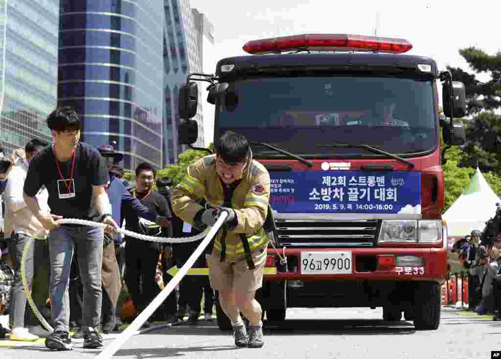 Firefighter Yeom Jung-phil pulls a fire truck by a rope during the Safe Seoul Festival in Seoul, South Korea.