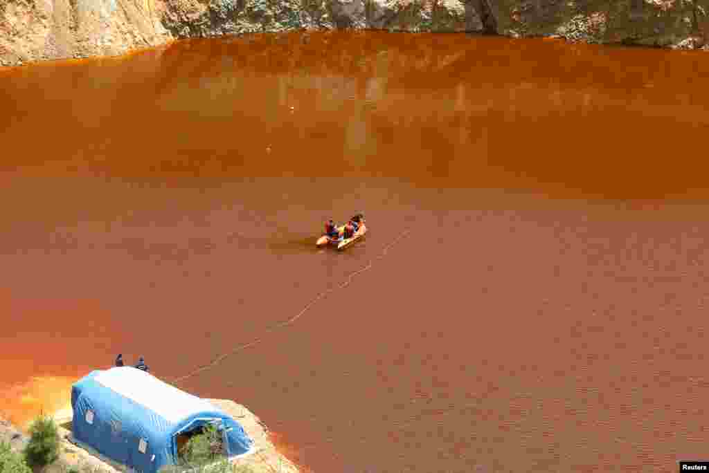 Forensics officers search Kokkinopezoula lake, also known as "red lake", for possible bodies of victims of a suspected serial killer near the village of Mitsero, Cyprus.