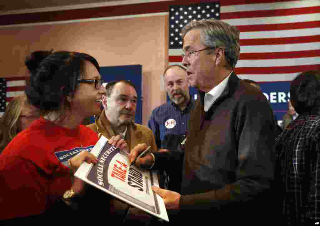 Republican presidential candidate, former Florida Gov. Jeb Bush, autographs a sign for a supporter at a campaign event, Feb. 8, 2016, in Portsmouth, N.H.