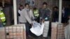Men remove the body of a suspected suicide bomber after an explosion was touched off at a mosque of a minority Ahmadiya Muslim sect, in Bagmara, Rajsahi district, Bangladesh, Dec. 25, 2015.